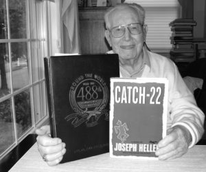 George Wells (Captain Wren) holding his 488th squadron yearbook from which most of Catch-22's characters were drawn. He flew 102 bombing missions, a WWII record.